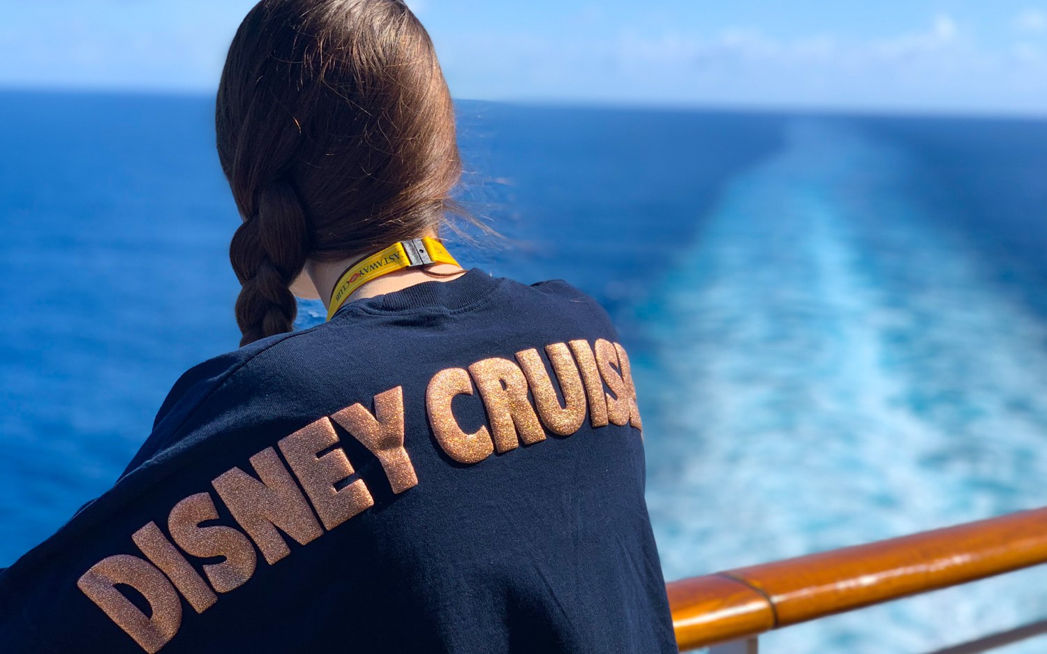 Wearing a Disney Cruise spirit jersey at the ship's rail, watching the wake stretch to the horizon